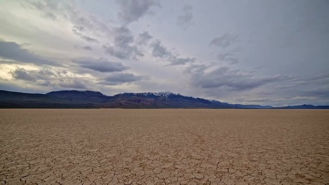 Colorful desert playa cracked earth Alvord Desert and storm Steens Mountain in distance 3