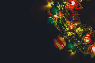 Greeting Season concept.Christmas wreath with decorative light on dark wood background