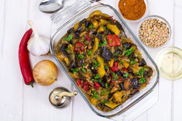 Vegetable saute with eggplant on white wooden background