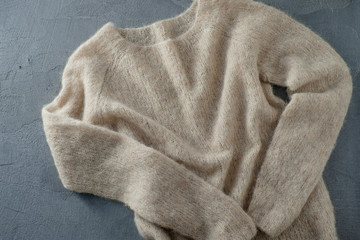 Beige knitted woolen sweater on a hanger