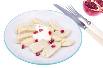 Dumplings from cottage cheese with yoghurt and pomegranate seeds