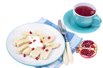 Dumplings from cottage cheese with yoghurt and pomegranate seeds