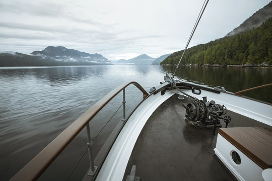 A boat travels through the coastal fjords of British Columbia's Great Bear Rainforest.