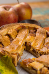 Traditional homemade apple pie with nuts and cinnamon close up and fresh ripe Golden Reinette apples