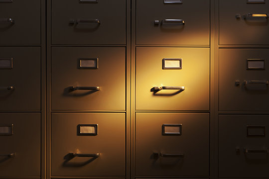 Spotlight shining on a wall of metal filing cabinets