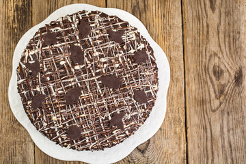 Homemade cake with chocolate icing on wooden table