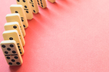 Rows of Dominoes from above on pink
