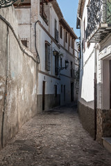 Old narrow street perspective at Albayzin district in Granada city, Spain