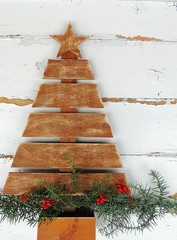Vintage wooden Christmas tree on old rustic wooden white background.