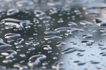 Wet car black color with water drops background