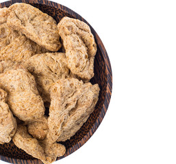 Dry soy slices of meat in wooden plate on white background