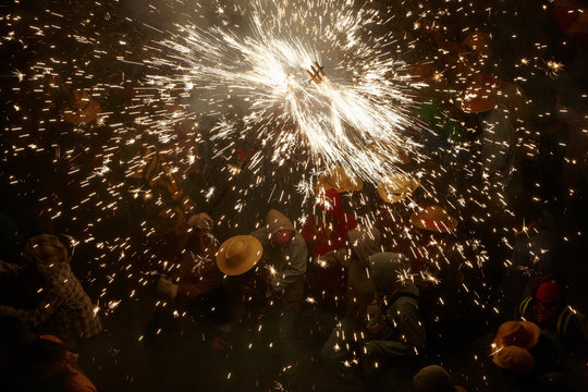 People under a rain of spinning fire sparks