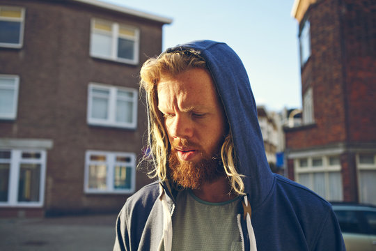 Young bearded ginger man wearing a hoody on a street