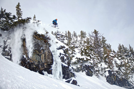 Skier jumping cliff in Whistler backcountry. Extreme ski