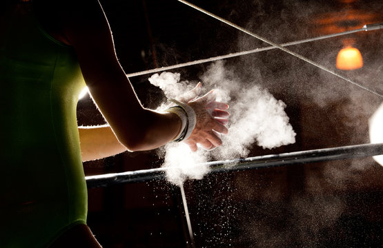 Chalk Talcum Powder Flies As Female Gymnast Preparess for Bars