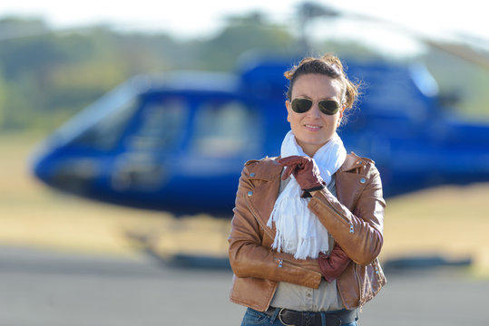 businesswoman standing in front of a helicopter