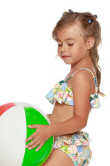 Little girl in a swimsuit with a ball