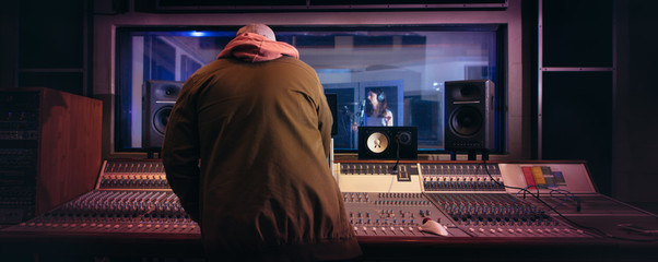 Musicians producing music in professional recording studio - obrazy, fototapety, plakaty