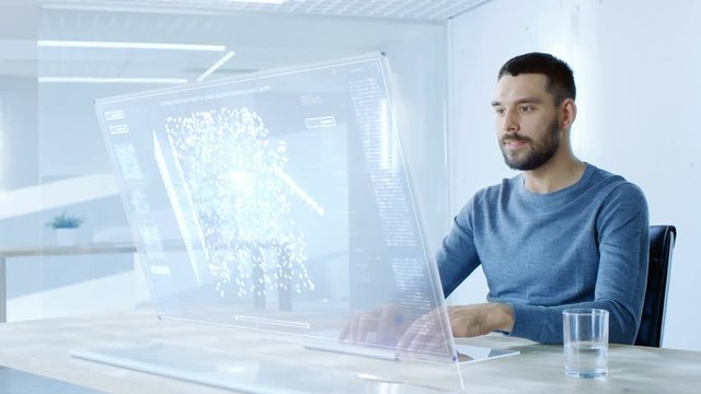 In the Near Future Man Working on His Computer with Transparent Display. Display Shows Graphic Projection of Neural Network, Artificial Intelligence Simulation. 