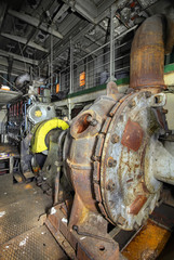 The ship's hold with diesel engine mounted on ship. Engine room on a old cargo boat ship.