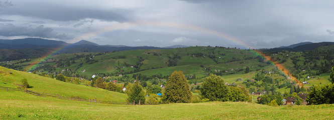 Rainbow over the villiage at the Carpatian mountains