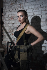 Girl with a gun in an abandoned factory