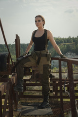 Girl with a gun in an abandoned factory