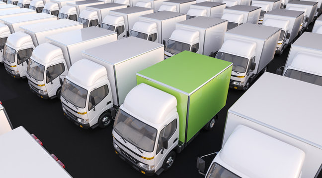 Group of White Delivery Trucks with One in Green Color