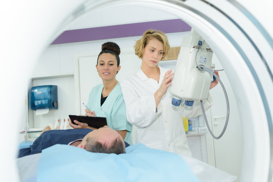 doctor assistant and patient in mri room at hospital