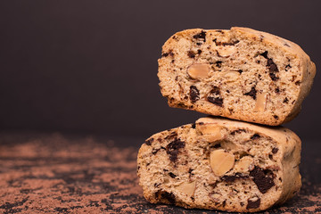Chocolate almond biscotti, cantucсini. Slice of chocolate biscotti on a black background, detail, macro, close-up.