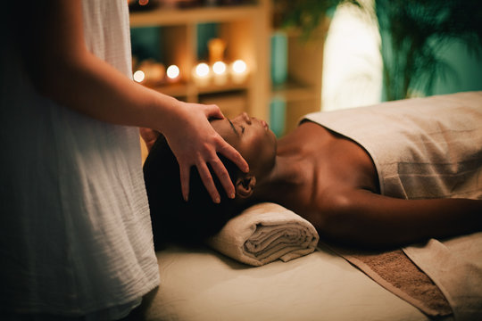 Woman receiving head massage at spa