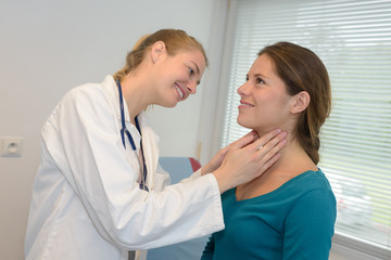 female doctor checking the throat of a young patient