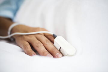 Obraz na płótnie Canvas Closeup of hand with finger pulse oximeter