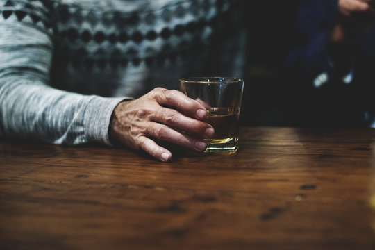 A Man Holding A Glass Of Whiskey