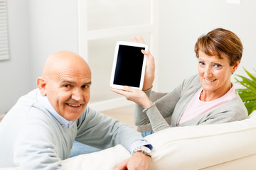 Obraz premium Mature couple displaying a blank tablet-pc