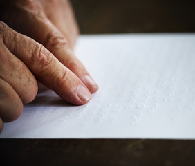 Closeup of hands touching reading braille letters