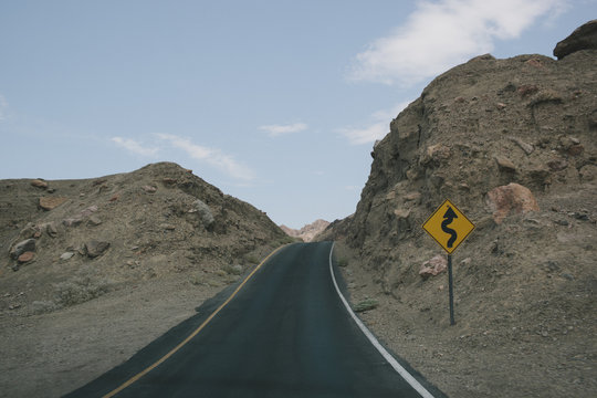 An empty road leading into the desert hills