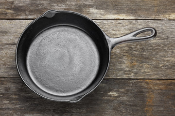 Empty cast iron skillet on weathered wood