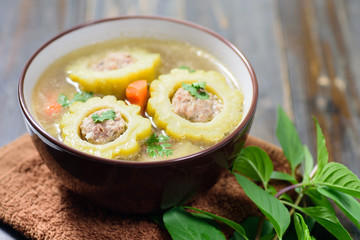 Thai food,bitter gourd soup with pork in a bowl on wooden background