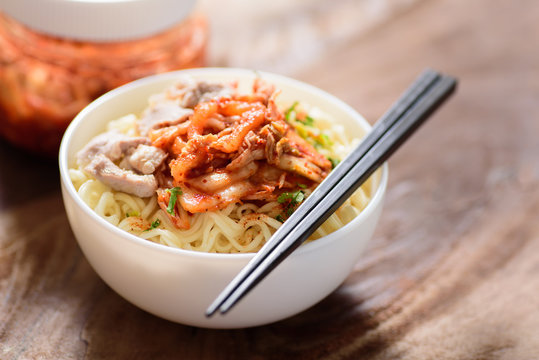 Korean food,instant noodle with kimchi cabbage in a bowl on wooden background