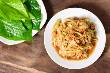 Thai food,spicy mango salad on white dish with vegetable.Top view of food