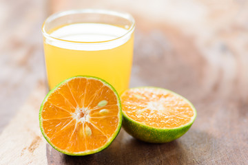 Green tangerine orange fruit and juice on wooden background, healthy food