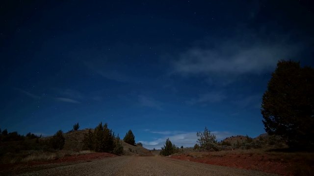 Empty gravel road under the moon and stars night near Painted Hills