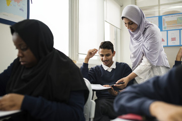 diverse muslim children studying in classroom