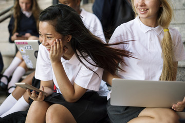 Group of students sitting on staircase using lptop