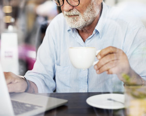 Elderly man is using computer laptop