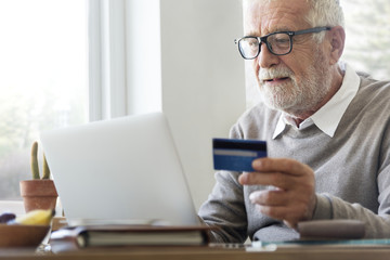 Senior man shopping online with a credit card - obrazy, fototapety, plakaty