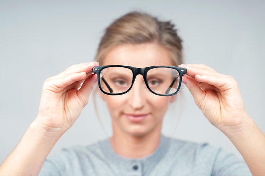 Woman optician with eyeglasses and frame in focus.