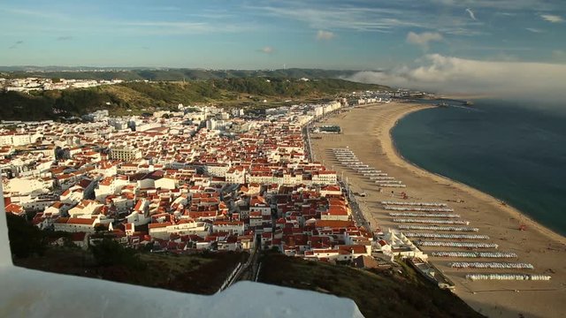 POV admiring Nazare skyline and beach waterfront from Miradouro do Suberco in Nazare Sitio, Central Portugal, Europe. touristic aerial view. Freedom and travel concept