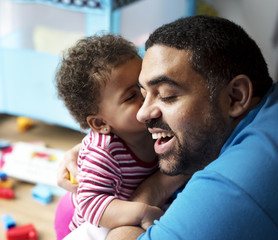 Fototapeta premium Little girl kissing dad on the cheek